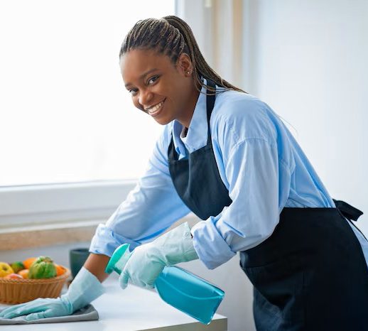 positive-african-american-maid-cleaning-kitchen-smiling_116547-51882